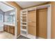Large walk-in closet with multiple built-in shelves and hanging rods, conveniently located next to the bathroom at 401 Crosshaven Way, Mcdonough, GA 30253