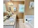 Bathroom with a double-sink vanity, granite countertops, and a bathtub with a tile surround at 507 Legacy Park Ln, Powder Springs, GA 30127