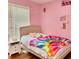 Cozy bedroom featuring pink walls, decor and light wood flooring, creating a welcoming space at 507 Legacy Park Ln, Powder Springs, GA 30127