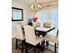 Elegant dining room with a dark wood table, upholstered chairs, and modern chandelier at 507 Legacy Park Ln, Powder Springs, GA 30127