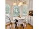 Eat-in kitchen includes modern chandelier, white table and chairs, and bright windows at 507 Legacy Park Ln, Powder Springs, GA 30127