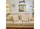 Comfortable living area with view into the kitchen, featuring a large sofa with decorative pillows at 507 Legacy Park Ln, Powder Springs, GA 30127