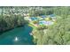 Aerial view of tennis courts, swimming pool, playground, and lake with dock, surrounded by lush greenery at 615 Brookwater Dr, Stockbridge, GA 30281