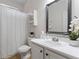 Bright bathroom with a white vanity, framed mirror, and shower with a curtain at 615 Brookwater Dr, Stockbridge, GA 30281