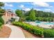 View of the community pool area with lounge chairs, umbrellas, and lush landscaping at 615 Brookwater Dr, Stockbridge, GA 30281