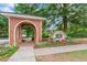 Charming brick entrance to the Monarch Village neighborhood with colorful flower beds and mature trees at 615 Brookwater Dr, Stockbridge, GA 30281