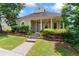Quaint home featuring a covered front porch with columns, lovely landscaping, and a welcoming entryway at 615 Brookwater Dr, Stockbridge, GA 30281