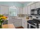 Bright kitchen featuring white cabinets, stainless steel appliances, and a mosaic backsplash at 615 Brookwater Dr, Stockbridge, GA 30281