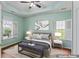 Staged bedroom featuring tray ceiling, ample natural light, and calming decor at 615 Brookwater Dr, Stockbridge, GA 30281
