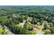 An aerial view of a suburban neighborhood surrounded by lush green trees on a sunny day at 625 Hickory Nobb, Sugar Hill, GA 30518