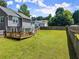Large backyard with an expansive lawn, wooden fence, and a cozy deck at 625 Hickory Nobb, Sugar Hill, GA 30518
