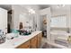 Bright bathroom featuring double sinks, soaking tub, and natural light at 625 Hickory Nobb, Sugar Hill, GA 30518