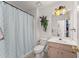 Bathroom with a shower featuring a patterned curtain, toilet, vanity with sink, and decorative mirror at 625 Hickory Nobb, Sugar Hill, GA 30518