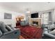 Spacious living room featuring a stone fireplace, hardwood floors, and stylish furnishings at 625 Hickory Nobb, Sugar Hill, GA 30518