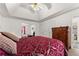 Main bedroom featuring a tray ceiling, large bed, wood dresser and an open walkway into the en suite bathroom at 625 Hickory Nobb, Sugar Hill, GA 30518
