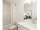 Bright bathroom with a shower-tub combo, white vanity, and a lovely decorative print at 2453 Honey Way, Conyers, GA 30013