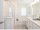 Bright bathroom featuring tile floors, bathtub, glass enclosed shower and double sink vanity at 2453 Honey Way, Conyers, GA 30013