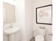 Small powder room featuring pedestal sink, toilet, framed artwork and mirror at 2453 Honey Way, Conyers, GA 30013