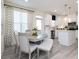 Eat-in kitchen featuring a dining table with seating, stainless steel appliances, and contemporary window treatments at 2453 Honey Way, Conyers, GA 30013