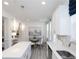 Bright kitchen with white cabinetry, quartz countertops, stainless steel sink, island with pendant lighting, and eat-in area at 2453 Honey Way, Conyers, GA 30013