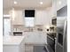 Modern, bright kitchen with stainless steel appliances, an island, and white cabinets at 2453 Honey Way, Conyers, GA 30013