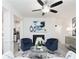 Living room boasts a ceiling fan, fireplace, and modern furnishings with blue accent pieces at 2453 Honey Way, Conyers, GA 30013