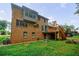 Brick home exterior with deck, manicured lawn, garden beds, and backyard patio at 5826 Andover Way, Tucker, GA 30084