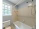 Shower and toilet inside bathroom with neutral paint and tile, and window with outside views at 5826 Andover Way, Tucker, GA 30084