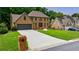 Brick home exterior featuring a large driveway and manicured lawn and landscaping at 5826 Andover Way, Tucker, GA 30084