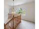 Hallway features a decorative chandelier, an arched window, and views of the outdoors, and wood banister at 5826 Andover Way, Tucker, GA 30084