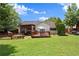 Lush backyard with a wooden deck, screened patio, and mature trees, perfect for outdoor living and recreation at 7030 Kingston Ln, Mcdonough, GA 30253