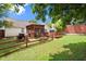 Spacious backyard featuring lush green grass, mature trees, a patio, and a wooden fence, ideal for entertaining at 7030 Kingston Ln, Mcdonough, GA 30253