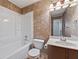Bathroom with a bathtub with shower, vanity, and toilet with a stylish accent wall at 1926 Cheatham Woods Sw Dr, Marietta, GA 30008