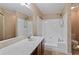 Bright bathroom featuring a soaking tub with white enclosure and a stylish vanity with a large mirror at 1926 Cheatham Woods Sw Dr, Marietta, GA 30008