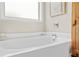 Close-up of a pristine white bathtub with tiled surround and faucet fixture at 2326 Britt St, Grayson, GA 30017