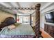 Elegant bedroom with a four-poster bed, tray ceiling, and adjoining sitting area with a fireplace at 2684 Mountain Oaks Ct, Powder Springs, GA 30127