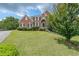 Charming brick home featuring a lush green lawn, manicured bushes and complemented by mature trees at 2684 Mountain Oaks Ct, Powder Springs, GA 30127