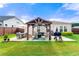 A serene backyard featuring a patio with grill, a covered gazebo with seating and dining, grass lawn, and wooden fencing at 3735 Westhaven Dr, Cumming, GA 30040
