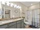 Bathroom featuring double sinks with granite counters, grey cabinets, a shower-tub combo and neutral paint at 3735 Westhaven Dr, Cumming, GA 30040