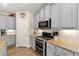 Modern kitchen with stainless appliances, gray cabinets, stone countertops, and sleek tile backsplash at 3735 Westhaven Dr, Cumming, GA 30040