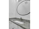 Bathroom featuring granite vanity, modern faucet, and round mirror at 4520 Coopers Creek Se Cir, Smyrna, GA 30082