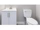 Bathroom features a white sink, vanity, gray walls, and a standard toilet at 4865 Fourth Rail Ln, Cumming, GA 30040