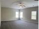 Spacious bedroom with neutral walls, plush gray carpet, and lots of natural light from the many windows at 4865 Fourth Rail Ln, Cumming, GA 30040