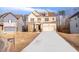 Two-story house with brick and tan siding, a well-maintained lawn, and a paved driveway leading to the two-car garage at 4865 Fourth Rail Ln, Cumming, GA 30040