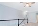Upstairs hallway with a decorative fan, gray walls, and black and white railing at 4865 Fourth Rail Ln, Cumming, GA 30040