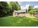 A well-maintained backyard featuring a wooden deck and a lush green lawn, surrounded by mature trees at 1066 Sea Oats Sw Way, Lilburn, GA 30047