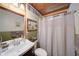 A charming bathroom with wood accents includes a vanity, toilet, and shower with a white curtain at 1066 Sea Oats Sw Way, Lilburn, GA 30047