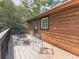 Side view of wooden deck featuring outdoor seating, wooden railing and log siding at 1166 Upper Sweetwater Se Trl, White, GA 30184