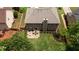 Aerial view of a home, featuring an outdoor patio, lush green lawn, and mature trees at 1810 Stardust Trl, Cumming, GA 30040
