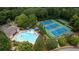 Aerial view of community pool, tennis courts, and basketball court surrounded by mature trees at 1810 Stardust Trl, Cumming, GA 30040